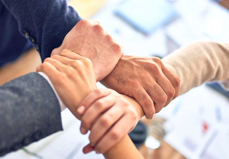 A valued sales team linking hands